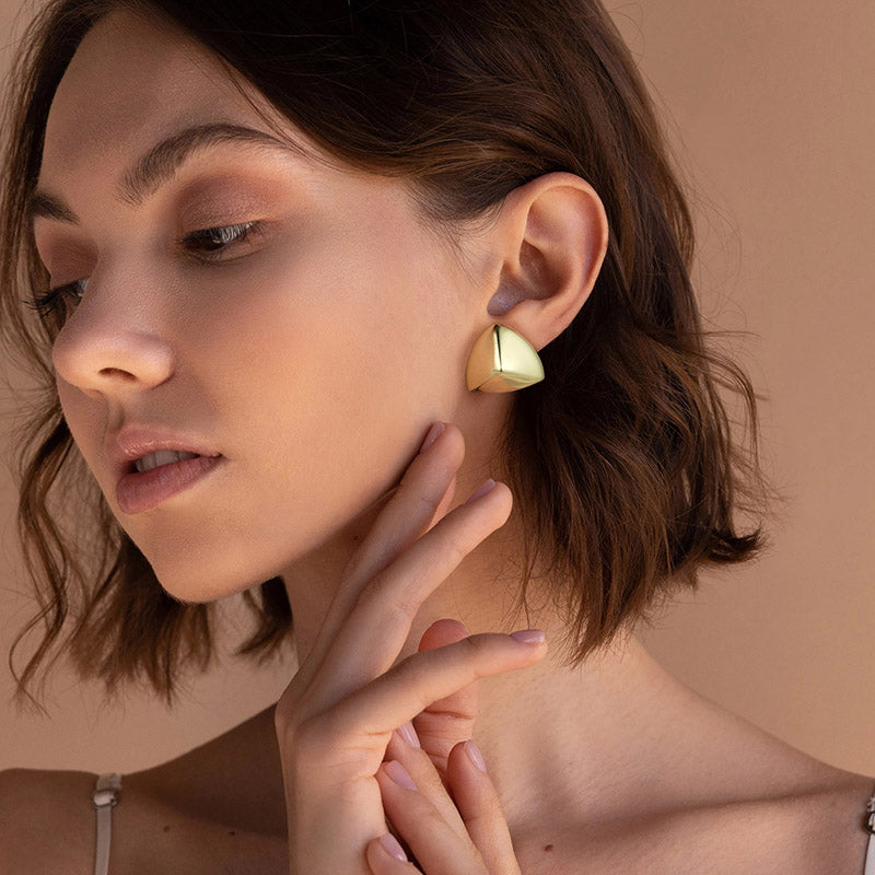 Golden, triangular protruding earrings