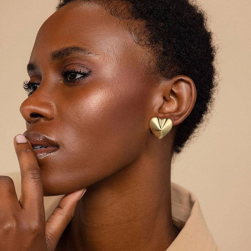 Golden-colored earrings with small raised hearts