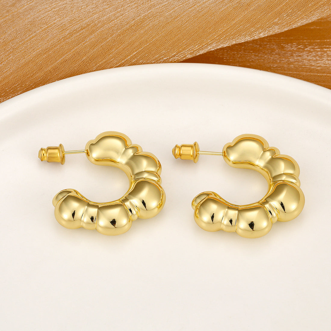 Golden-colored, large C-shaped thick earrings