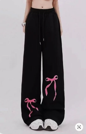 Black, women's casual pants with pink ribbon bow pattern below both legs
